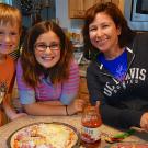 Susan Rivera and her two children making pizza at home