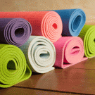 Seven yoga mats, rolled up and stacked
