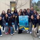 A group of students, Franchesca and Center for Leadership and Learning staff posing for a photo around a "Mapping your journey" poster outside of the UC Davis Conference Center.