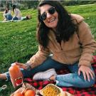 Anna Fox poses in front of a big meal of food at a farmers market at UC Davis. 