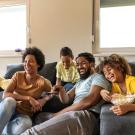 Family watching TV together on couch at home