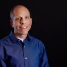 Man in a blue shirt with a black plain background