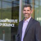 Ned Spang, associate professor of food science and technology, named new director of Robert Mondavi Institute. He stands in front of the institute's logo on a glass door. (Jael Mackendorf/UC Davis)