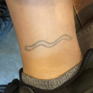 Tattoo of worm on ankle