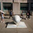 Students walk by the Bookhead sculpture on the UC Davis campus.
