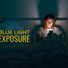 Photo shows person looking at phone with text: Blue light exposure