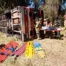 Firefighters remove actor from bus that is rolled over on its side for training incident.