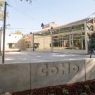 CoHo building and concrete plaza with trees and raised lettering