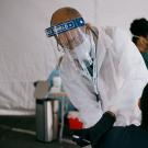 UC President Michael V. Drake, in lab coat, administers a vaccination.