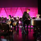 Composer on stage lighted in pink