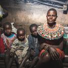Three young children sit next to their mother in their home in Samburu, Kenya.