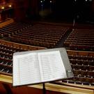 Sheet music rests against a stand in front of several rows of seats facing the stage at the Mondavi Center.