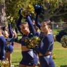Members of the UC Davis Cheer Team raises pompoms at 2021 Homecoming Pep Rally