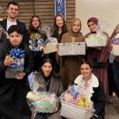 Group of people pose for photo holding gift baskets.