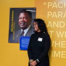 Michele Butler-Robinson stands next to photo of Walter Robinson at Welcome Center.