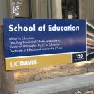 "School of Education" exterior sign featuring fanned pages of a book
