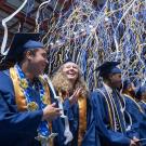 Three graduates beam as streamers fall