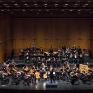 symphony performing on darkened stage