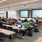 Instructor lectures in large lecture hall