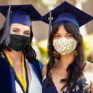 Students wearing face coverings and graduation regalia.