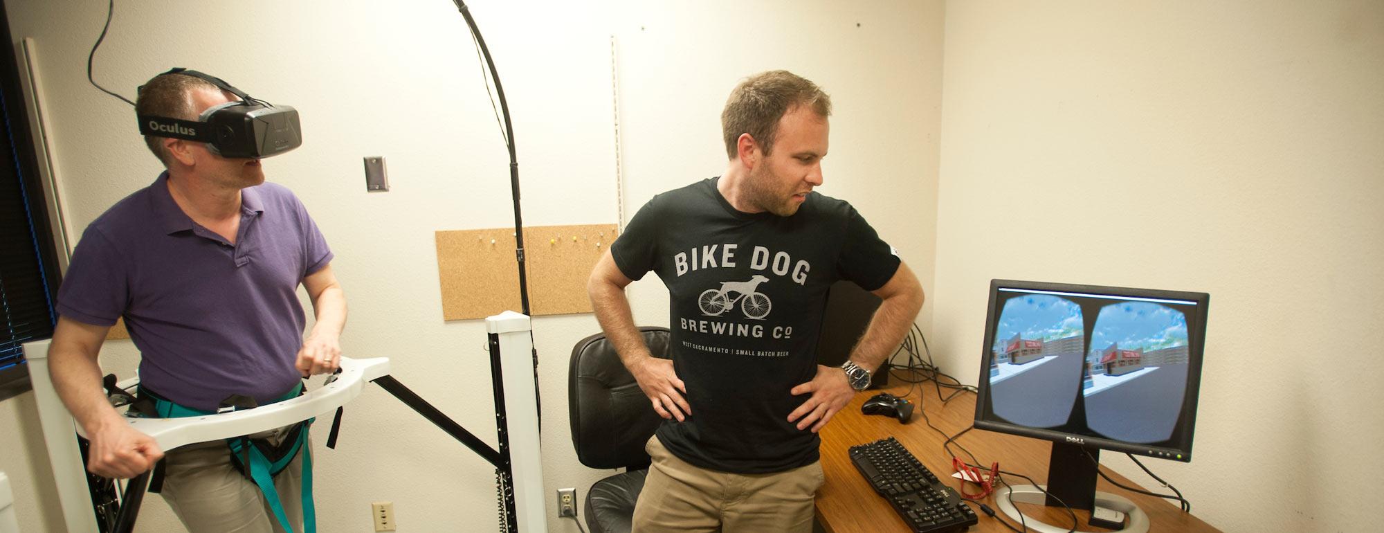 A test subject uses a haptic treadmill will a researcher observes his virtual actions