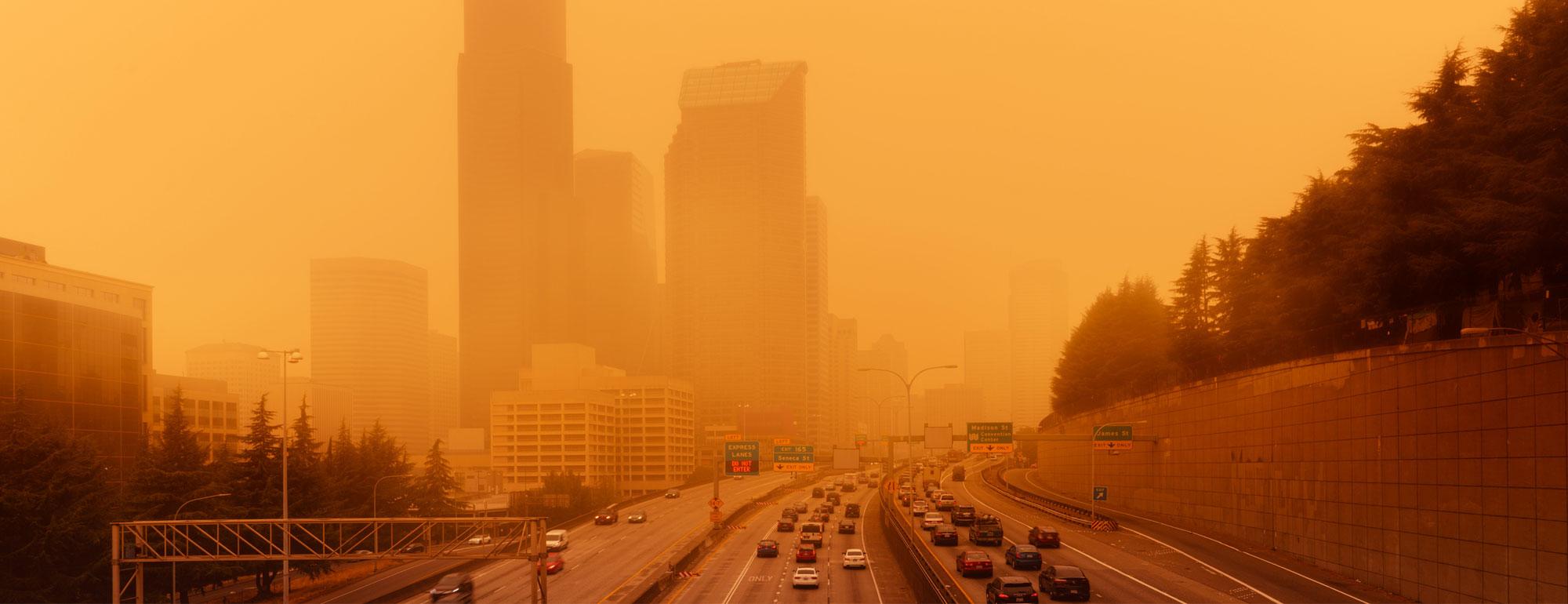 a polluted skyline with a freeway in the foreground