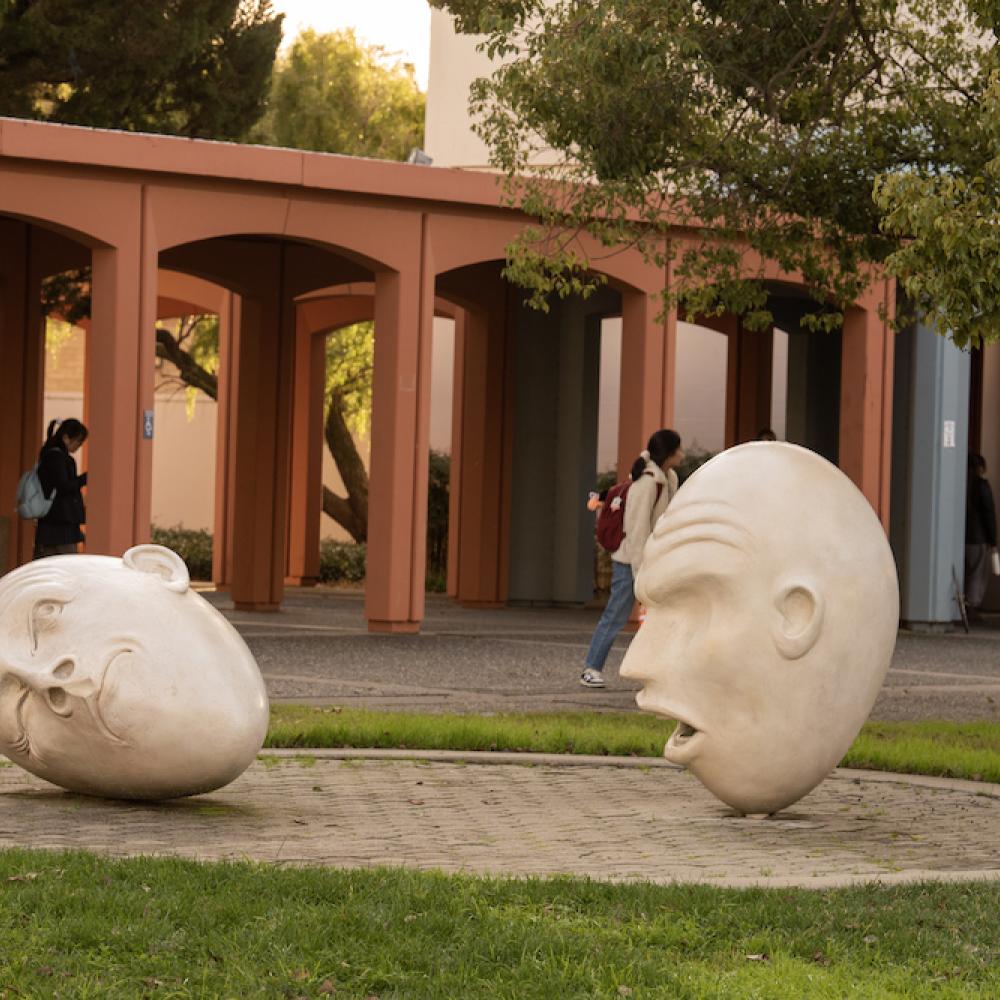 Yin and Yang egghead sculpture at golden hour on UC Davis campus