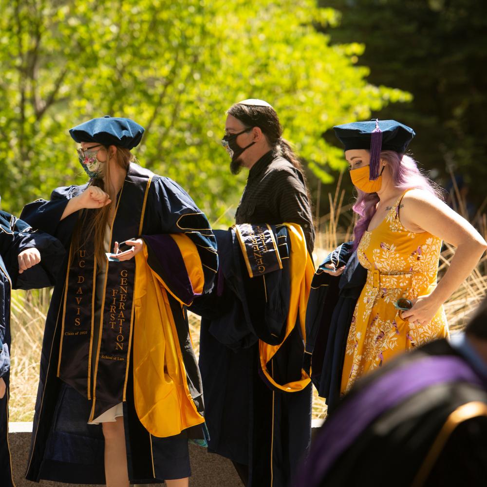 students gather in commencement regalia at UC Davis