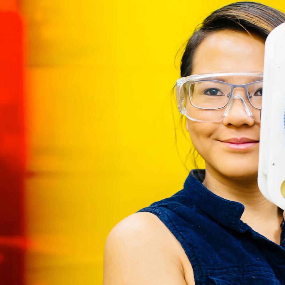 A UC Davis Biomedical Engineering alum poses with here vision improvement invention