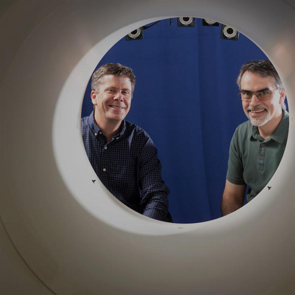 Two researchers stair through the opening to a full body PET scan maching that UC Davis pioneered.