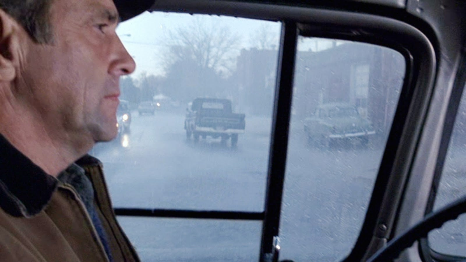 Man in hat sitting in a pickup truck