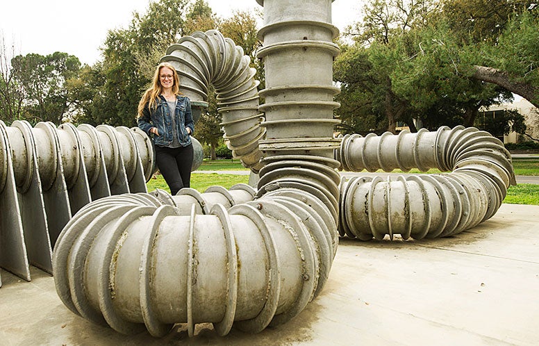 Woman standing on large pipe structure