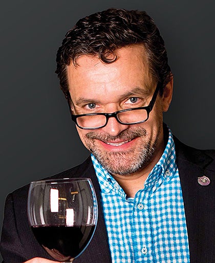 Portrait of Christian Butzke holding a glass of wine
