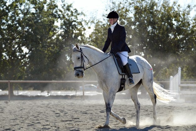 Woman riding a white horse