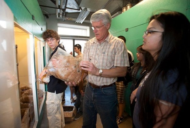 Professor and students inspecting a bag of mushrooms