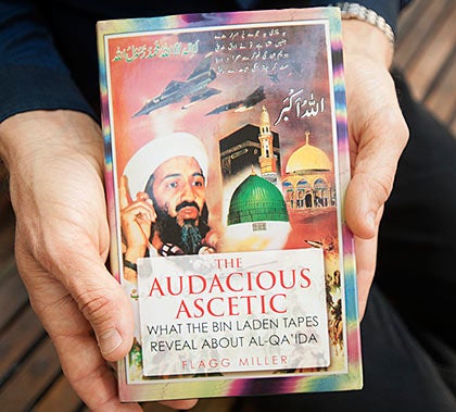 Hands holding a book titled "The Audacious Ascetic