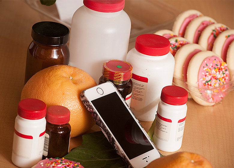 A photo with grapefruit, sugar cookies, medicine bottles and a mobile phone