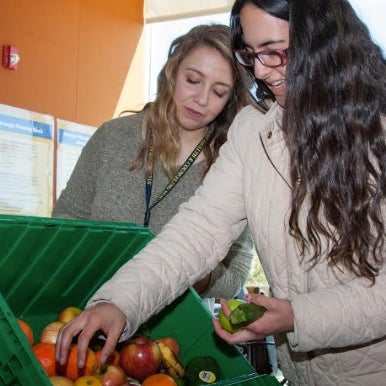 A student reaches for some produce