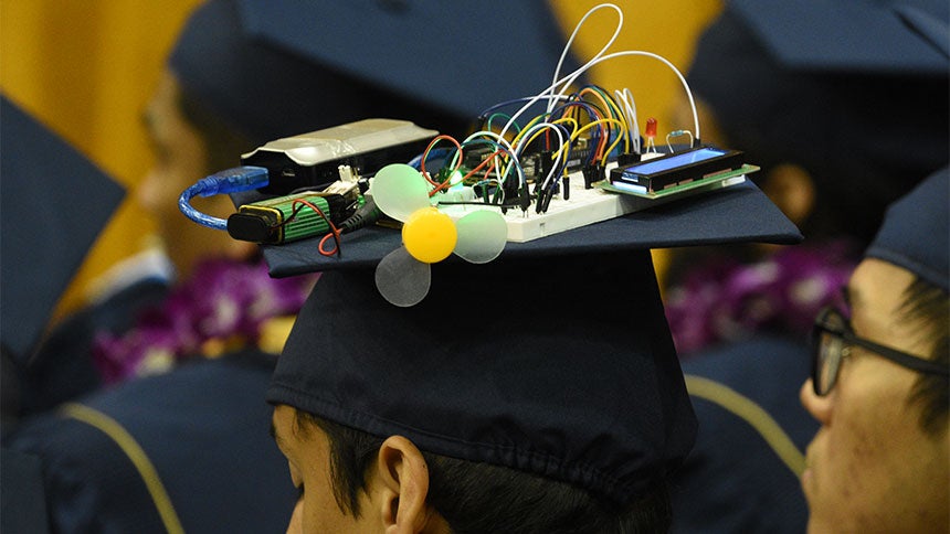 A closeup of a graduation cap decorated with circuits