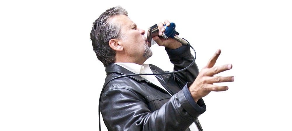Harmonicist Mitch Kashmar playing the harmonica, wearing a leather jacket.