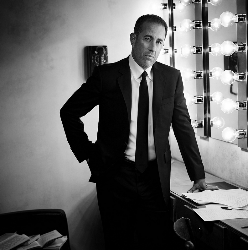 Jerry Seinfeld standing in a dressing room backstage.