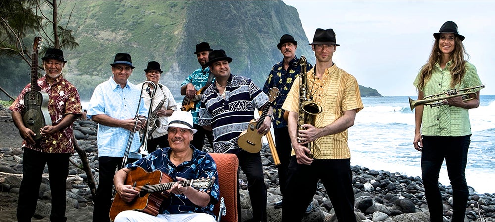 The Kahulanui band standing on a Hawaiian beach.