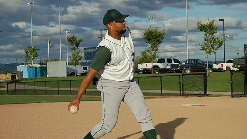 a man pitches a softball