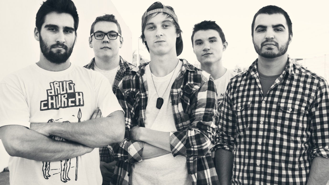Members of State Champs standing before a white background.