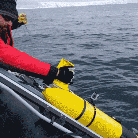 A researcher launches the ice glider from the boat into the antarctic waters.